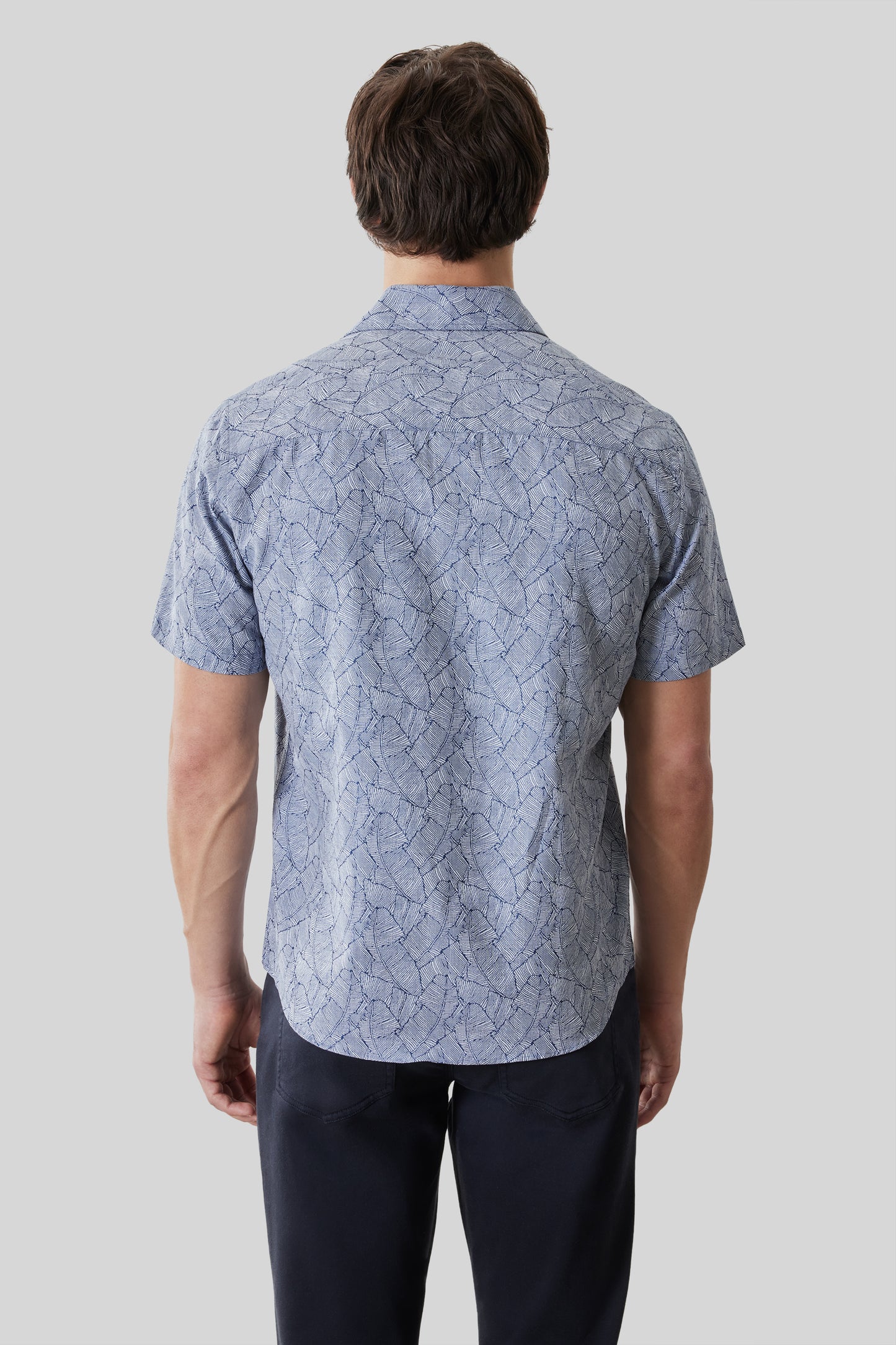 Light blue short sleeve shirt with geometric line pattern, shown on model from back view.