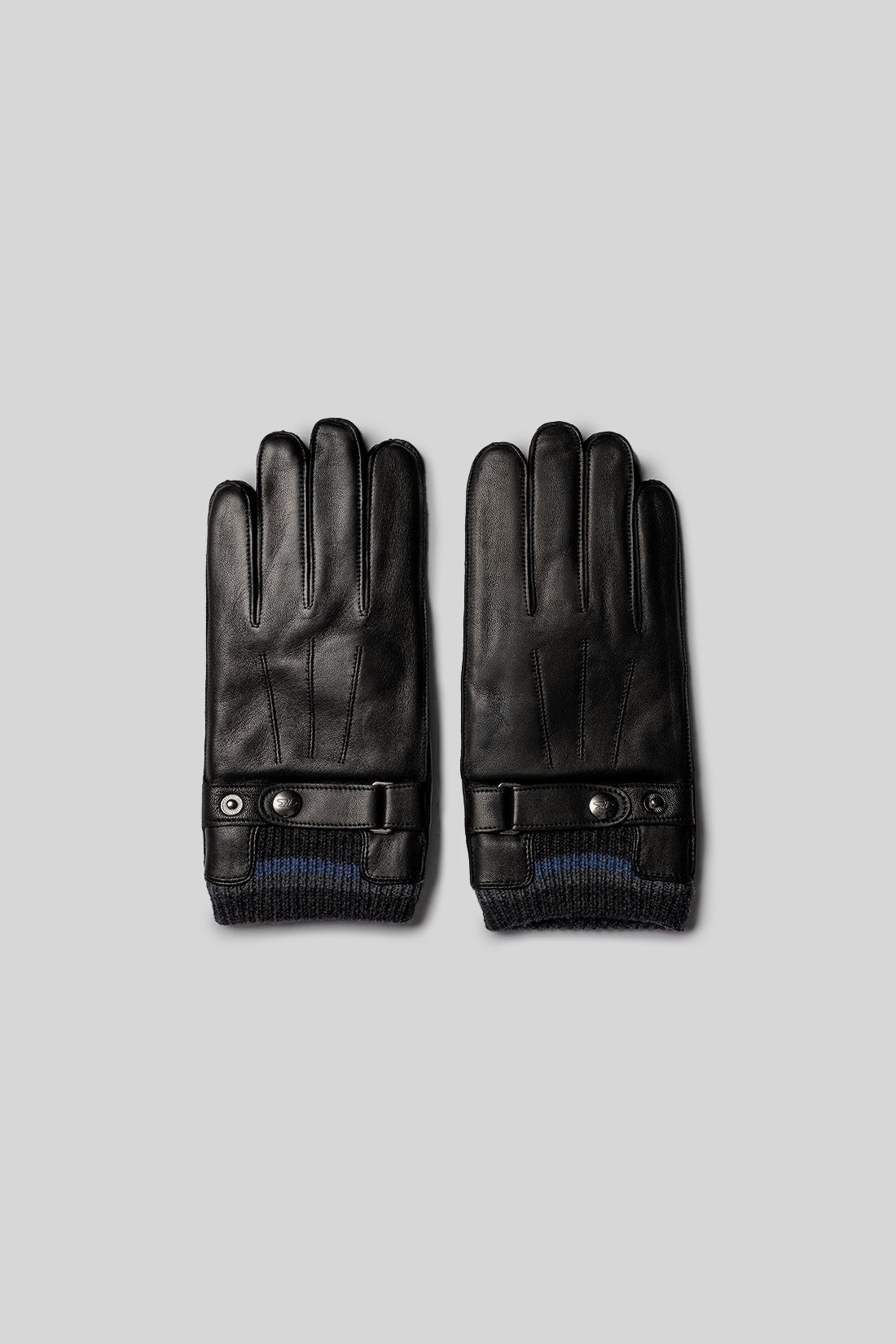 Black leather gloves with adjustable wrist straps, ribbed cuffs, and metal snap closures.