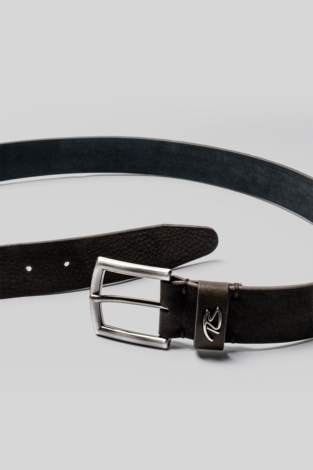 Black leather belt with rectangular silver buckle, adjustment holes, and textured leather strap.