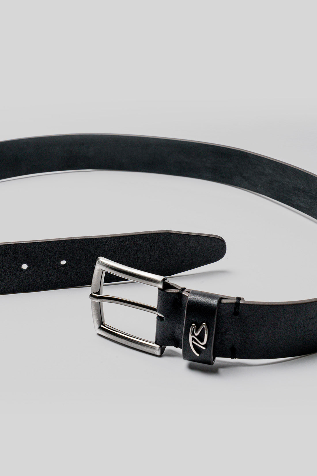 Black leather belt with silver-tone rectangular buckle and branded keeper loop detail.