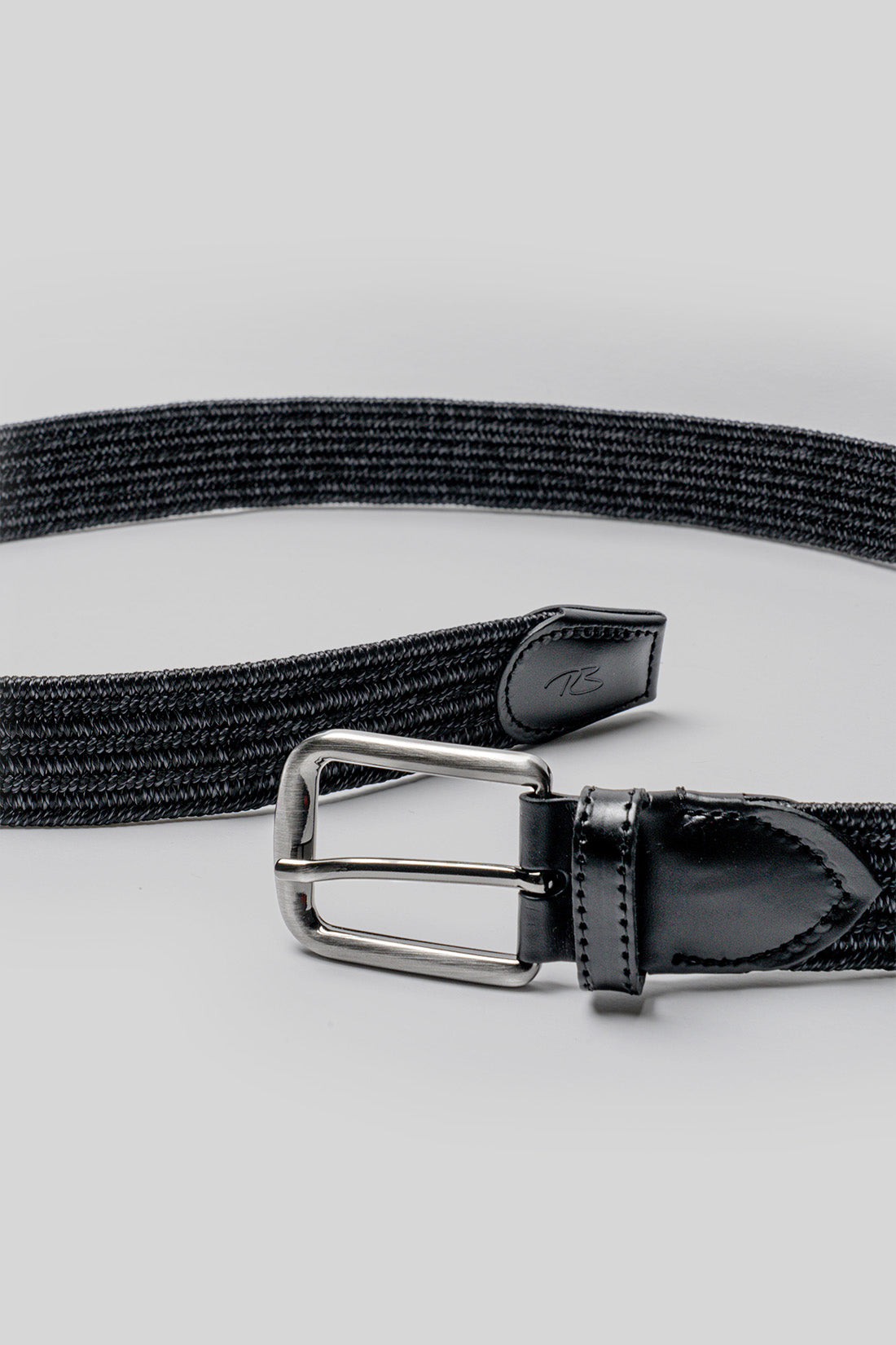 Black fabric belt with silver buckle and leather trim detail at the ends.
