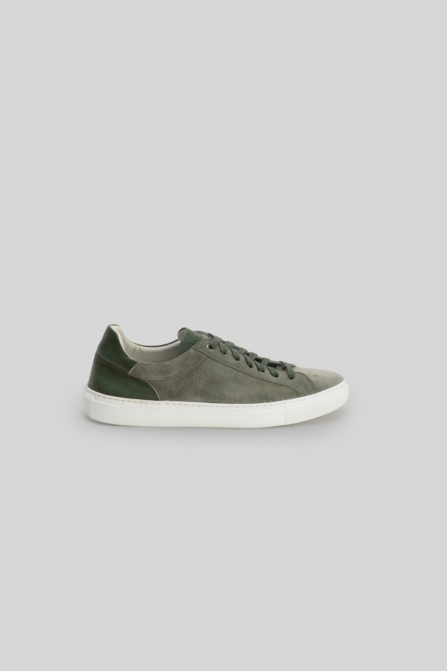 Gray and green suede sneaker with white rubber sole and dark laces, shown in profile view.