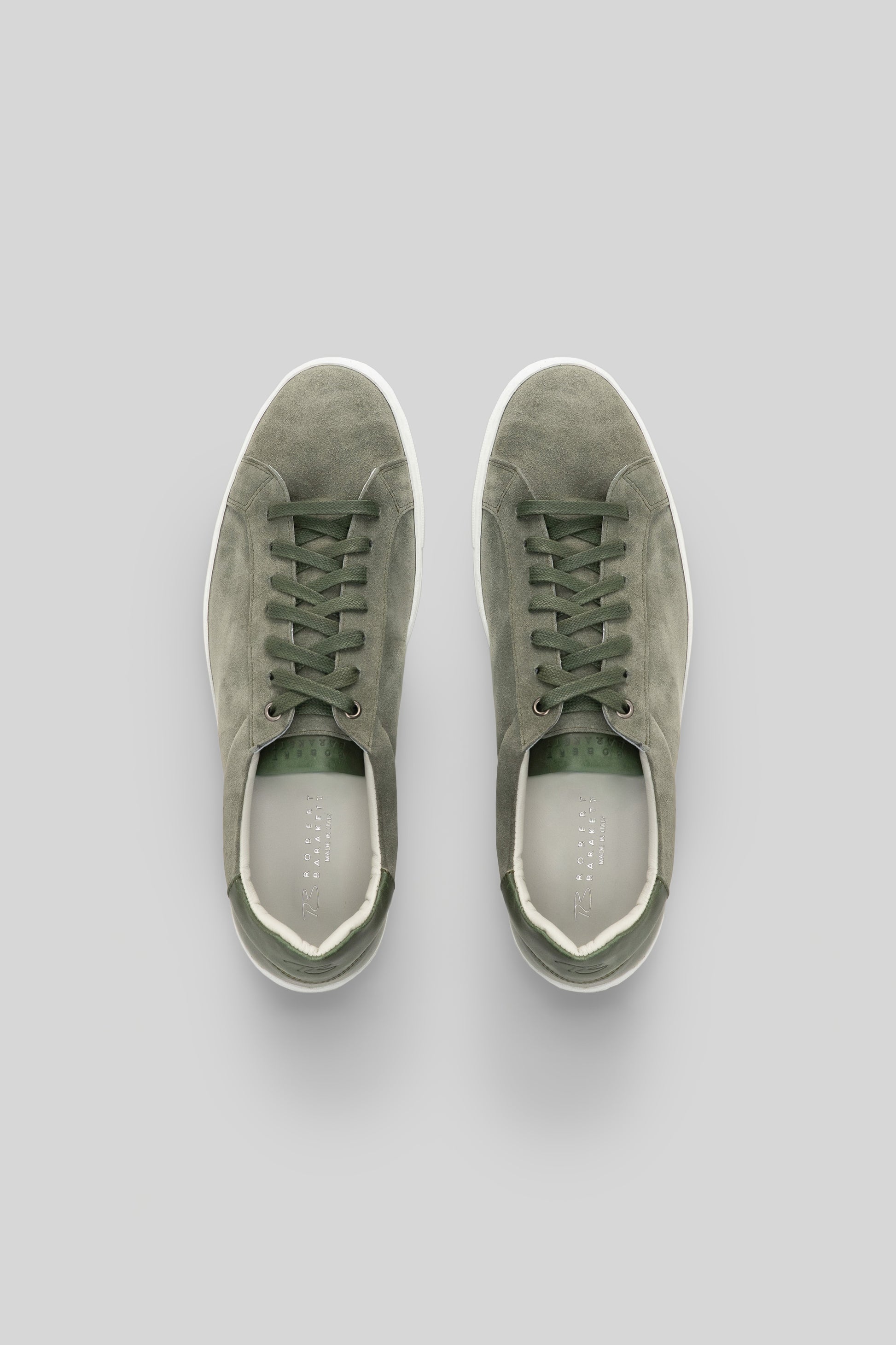Sage green suede sneakers with white rubber sole and lace-up closure, shown from top view.