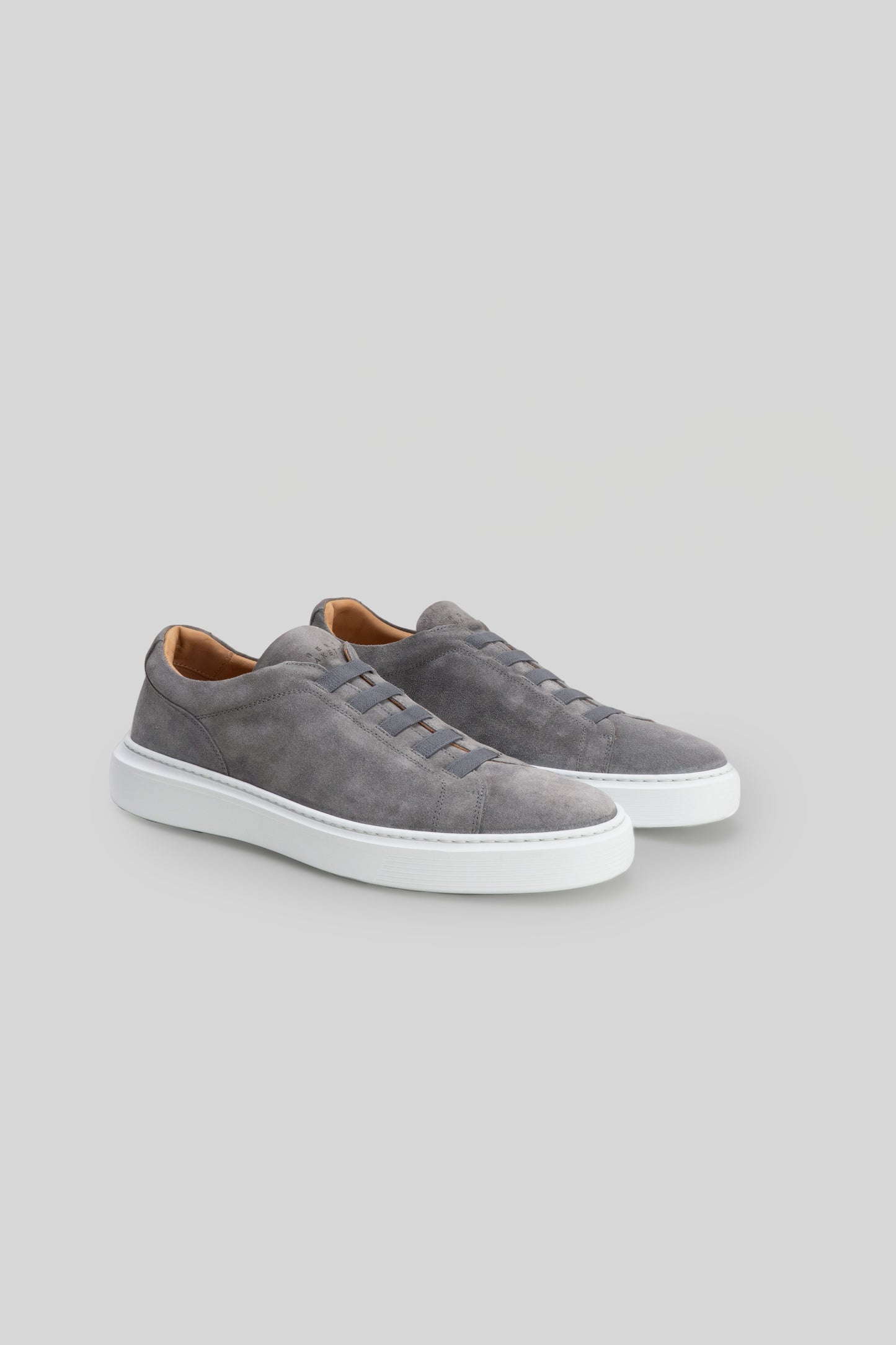 Gray suede slip-on sneakers with white sole and tan interior lining.