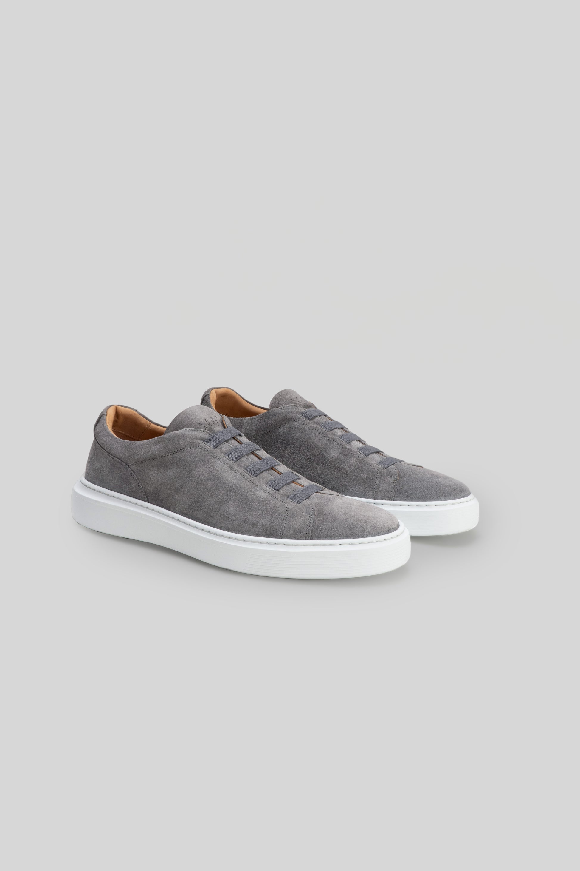 Gray suede slip-on sneakers with white sole and tan interior lining.