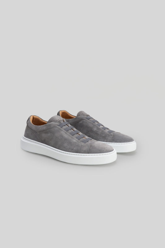 Gray suede slip-on sneakers with white sole and tan interior lining.