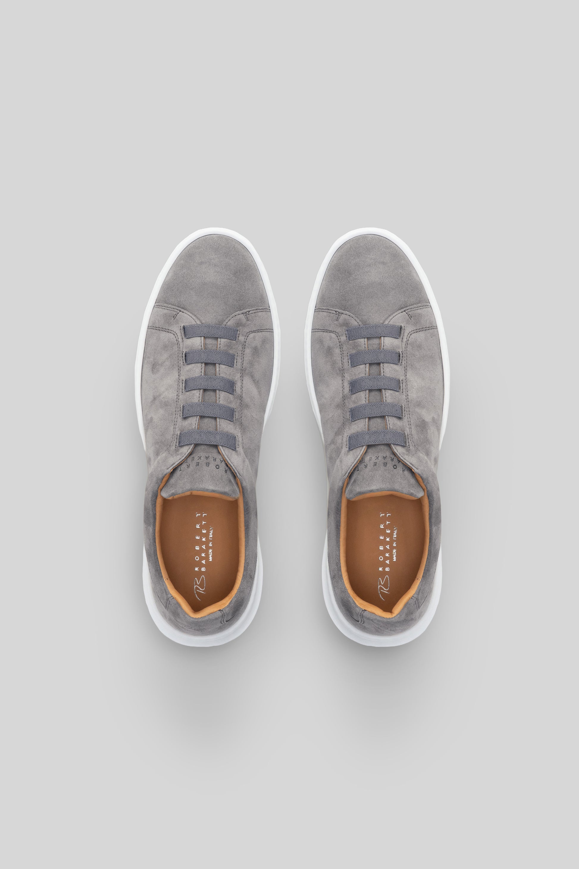 Gray suede lace-up sneaker with white sole and tan interior, shown from above.