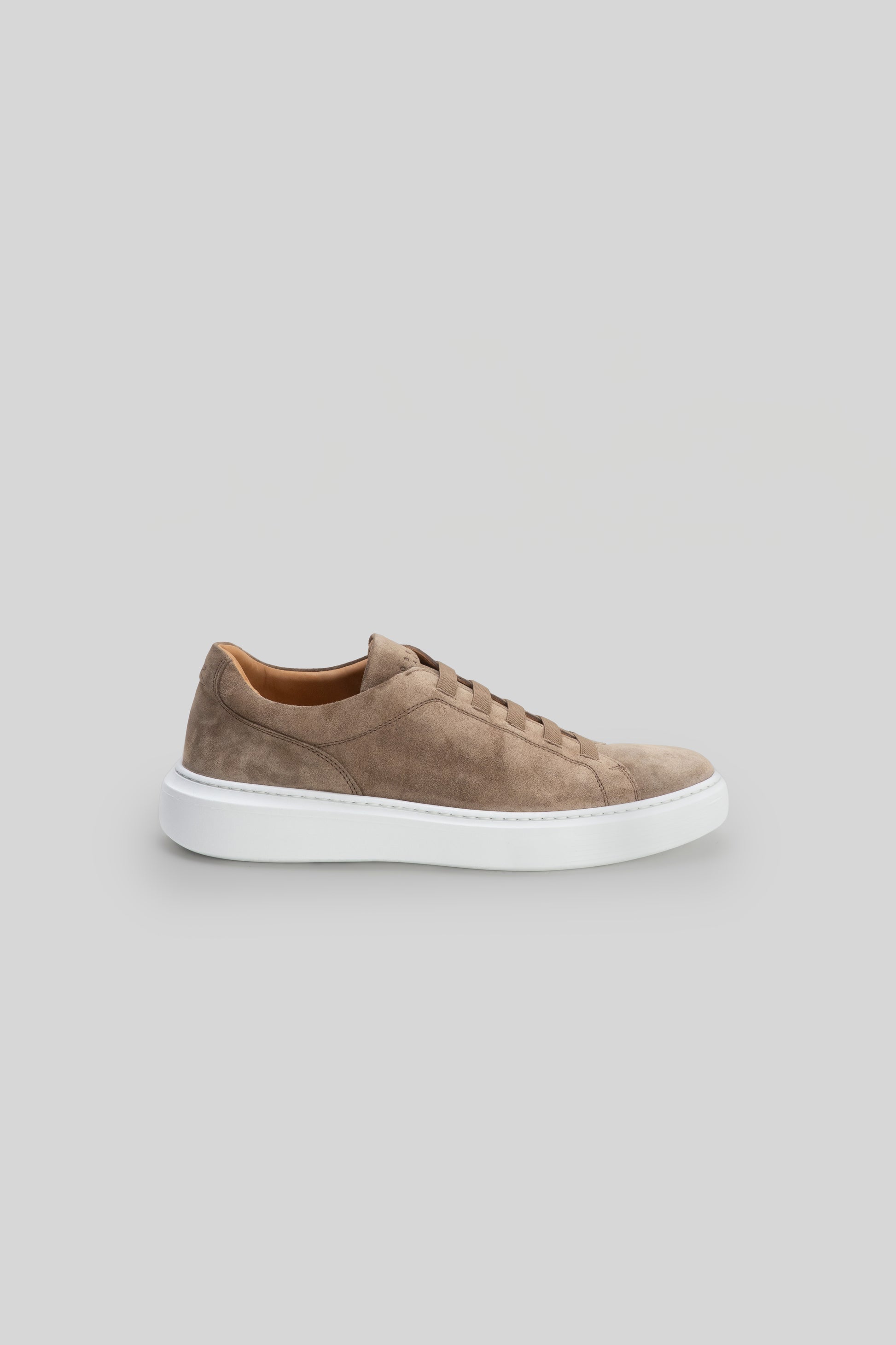 Taupe suede sneaker with elastic lacing and white sole, shown in side profile.