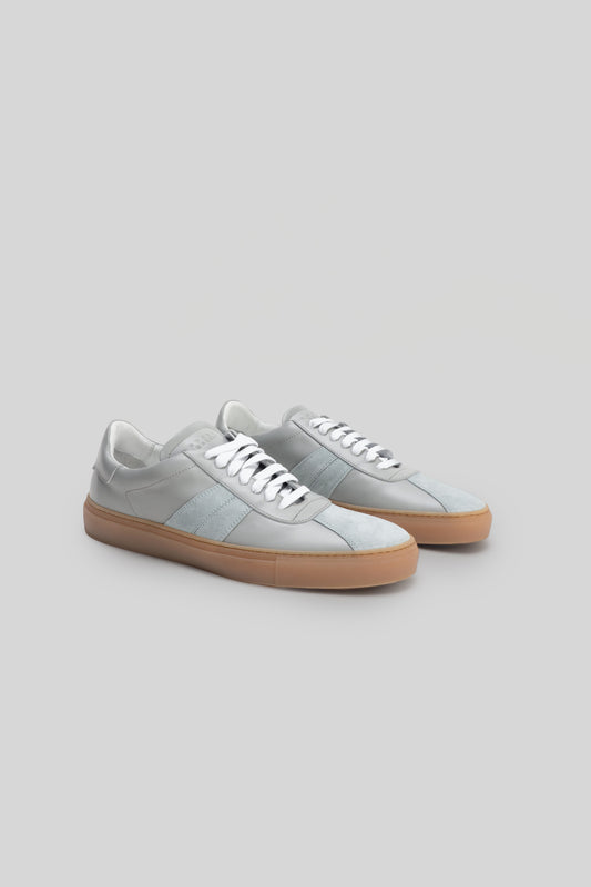 Light blue and white striped sneaker with white laces and gum rubber sole, shown from the side.