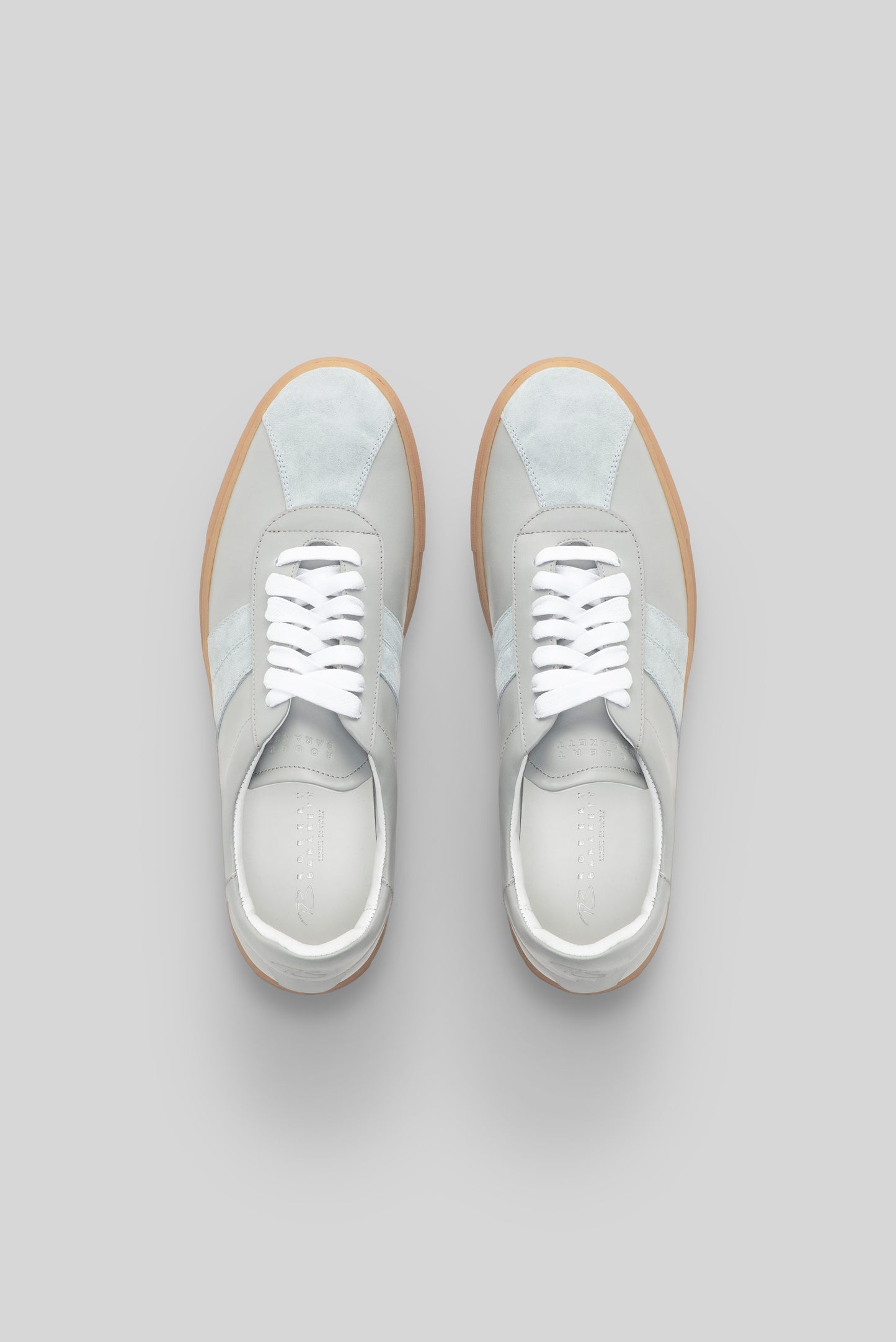 White and gray striped sneakers with white laces and tan rubber sole, shown from above.