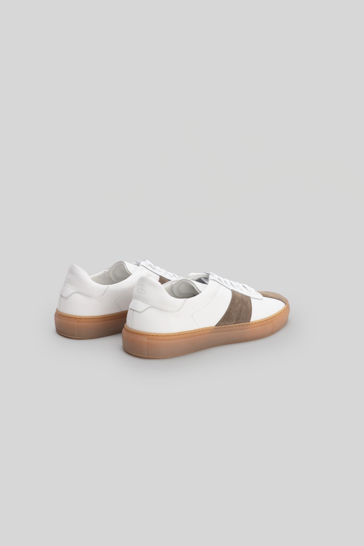 White and taupe striped sneaker with tan rubber sole, shown from rear three-quarter view.