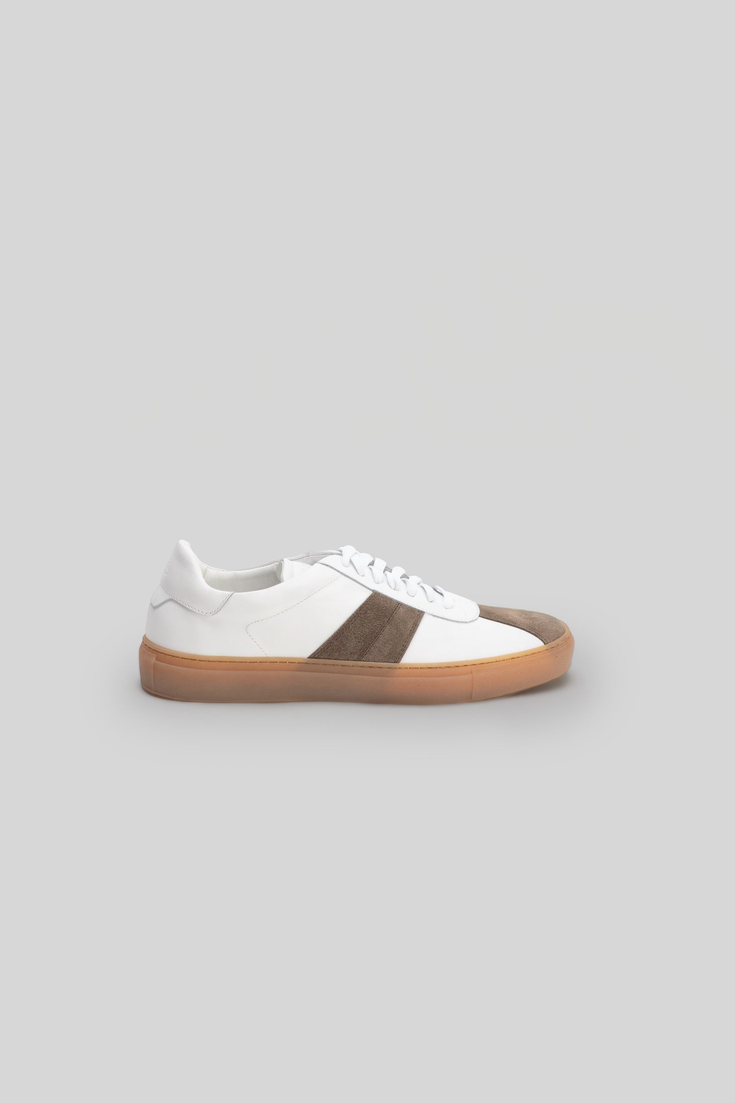 White leather sneaker with brown stripe and gum sole, lace-up closure and padded collar.
