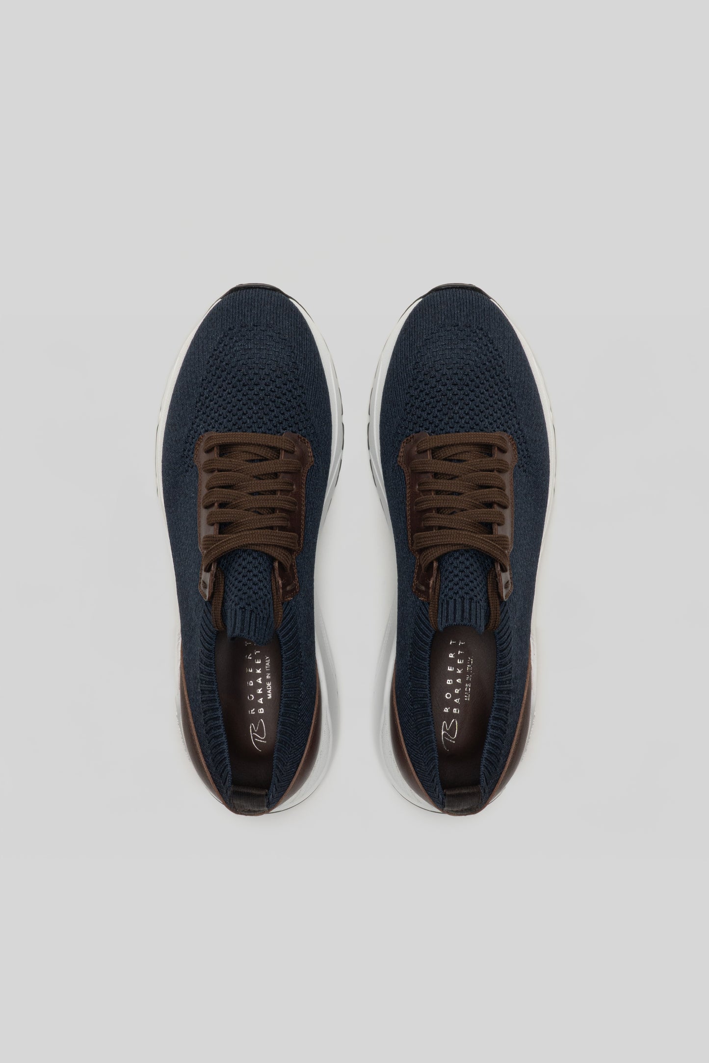 Navy knit sneakers with brown laces and white sole, shown from above.