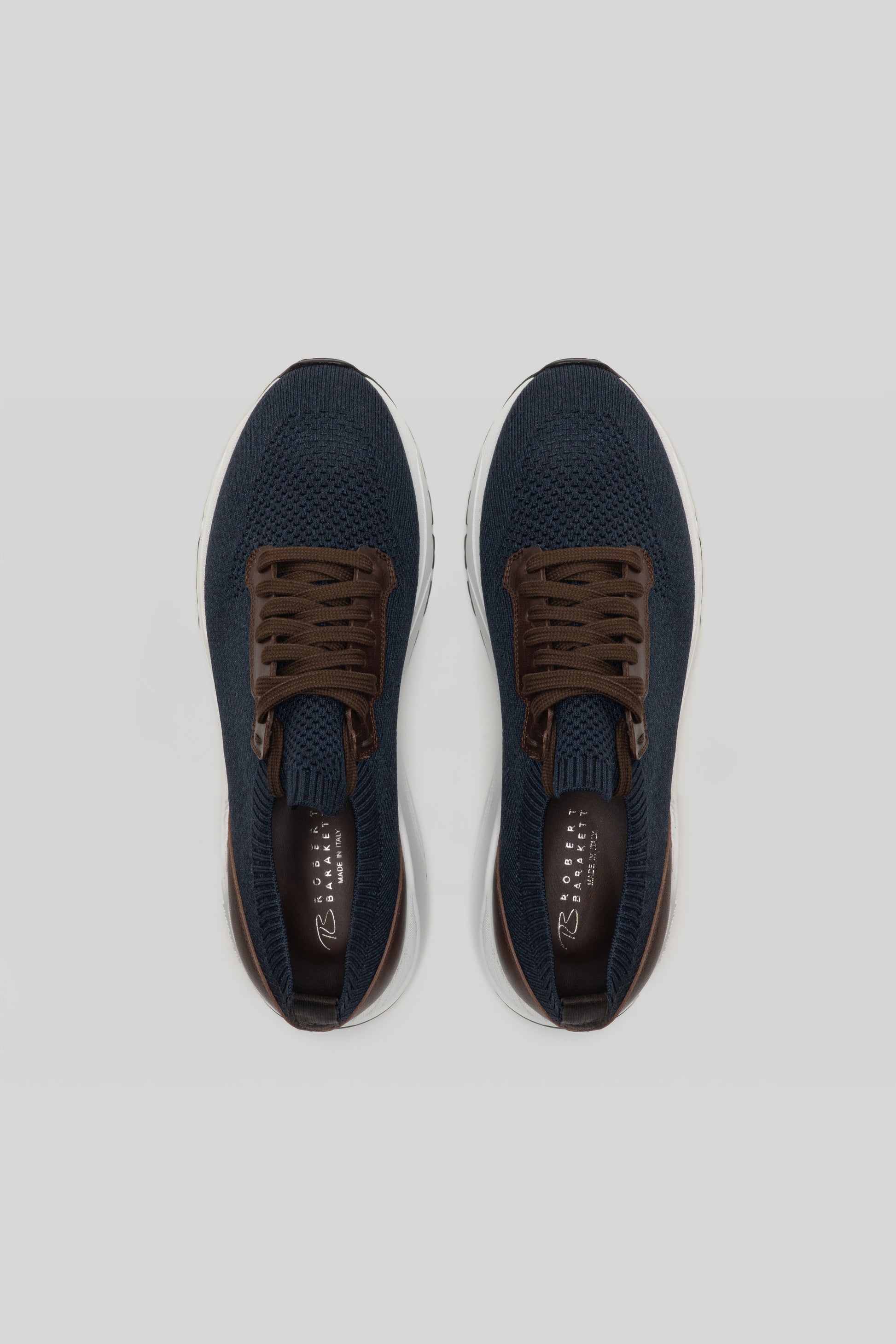 Navy knit sneakers with brown laces and white sole, shown from above.