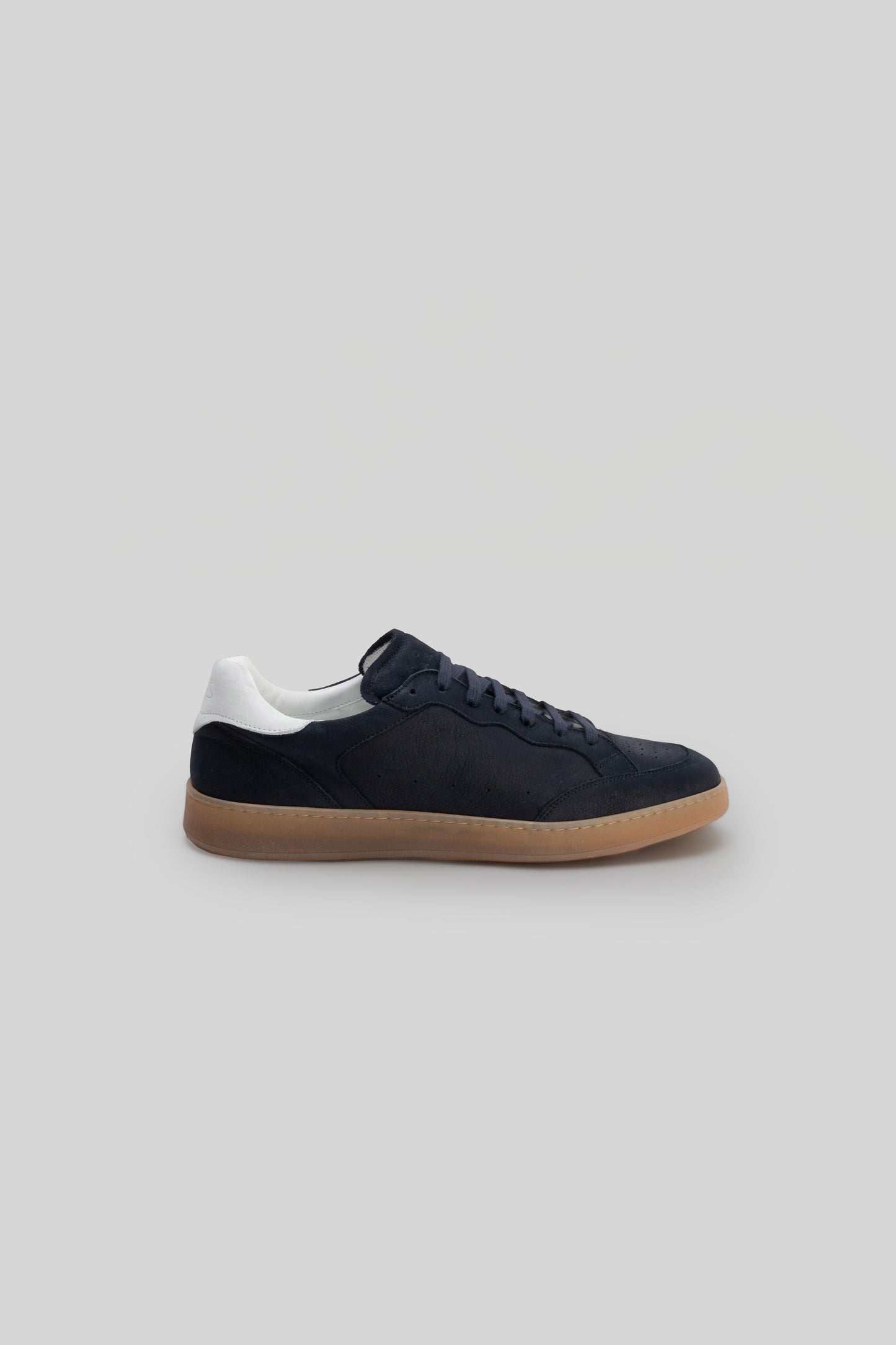 Black leather court sneaker with white collar trim and tan gum sole, shown in side profile.
