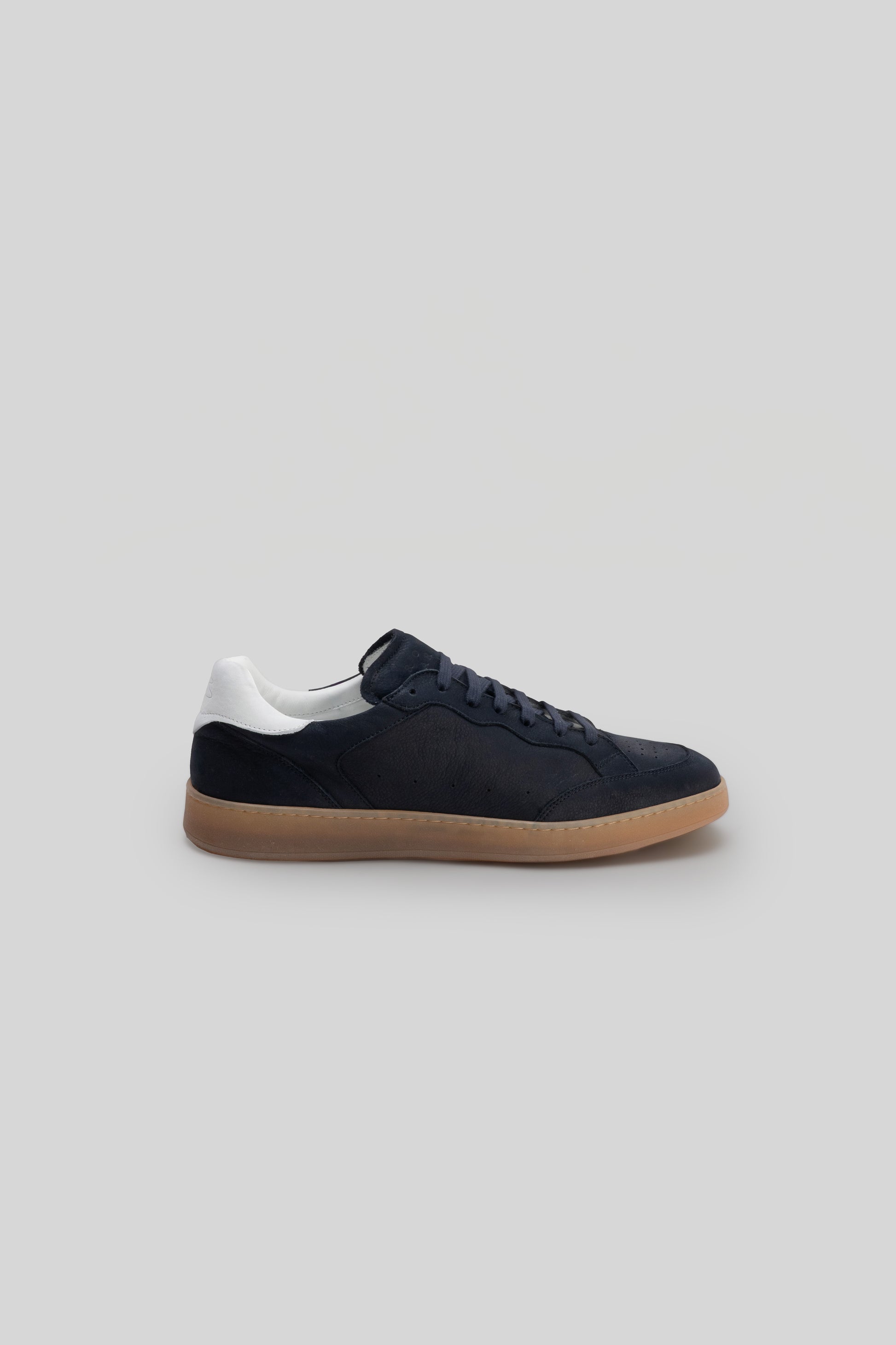 Black leather court sneaker with white collar trim and tan gum sole, shown in side profile.