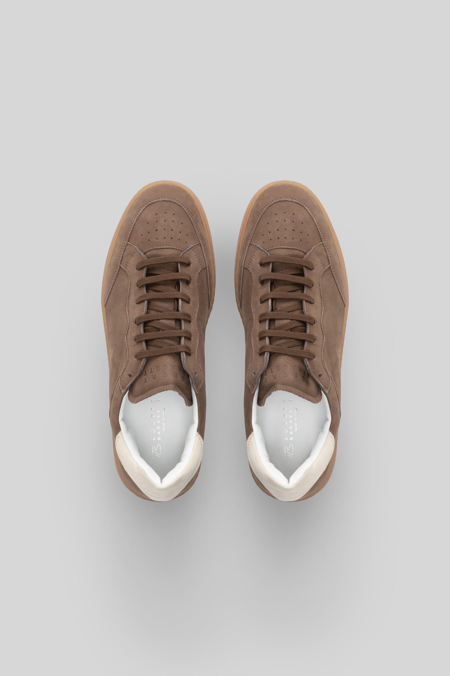 Pair of taupe suede court sneakers with white leather heel counter and gum sole, lace-up closure, top view.