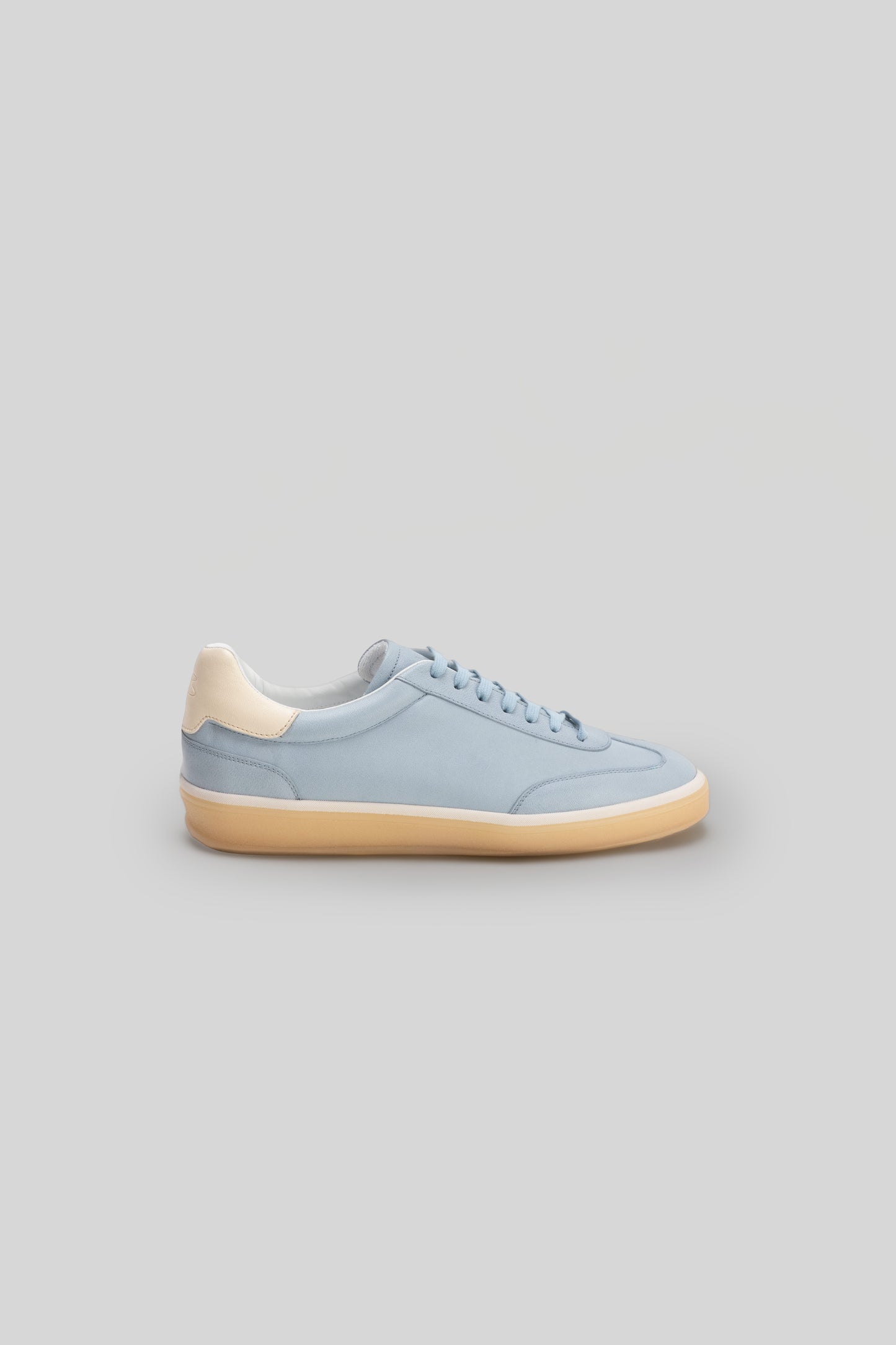 Light blue sneaker with cream-colored heel tab and tan sole, shown in side profile view.