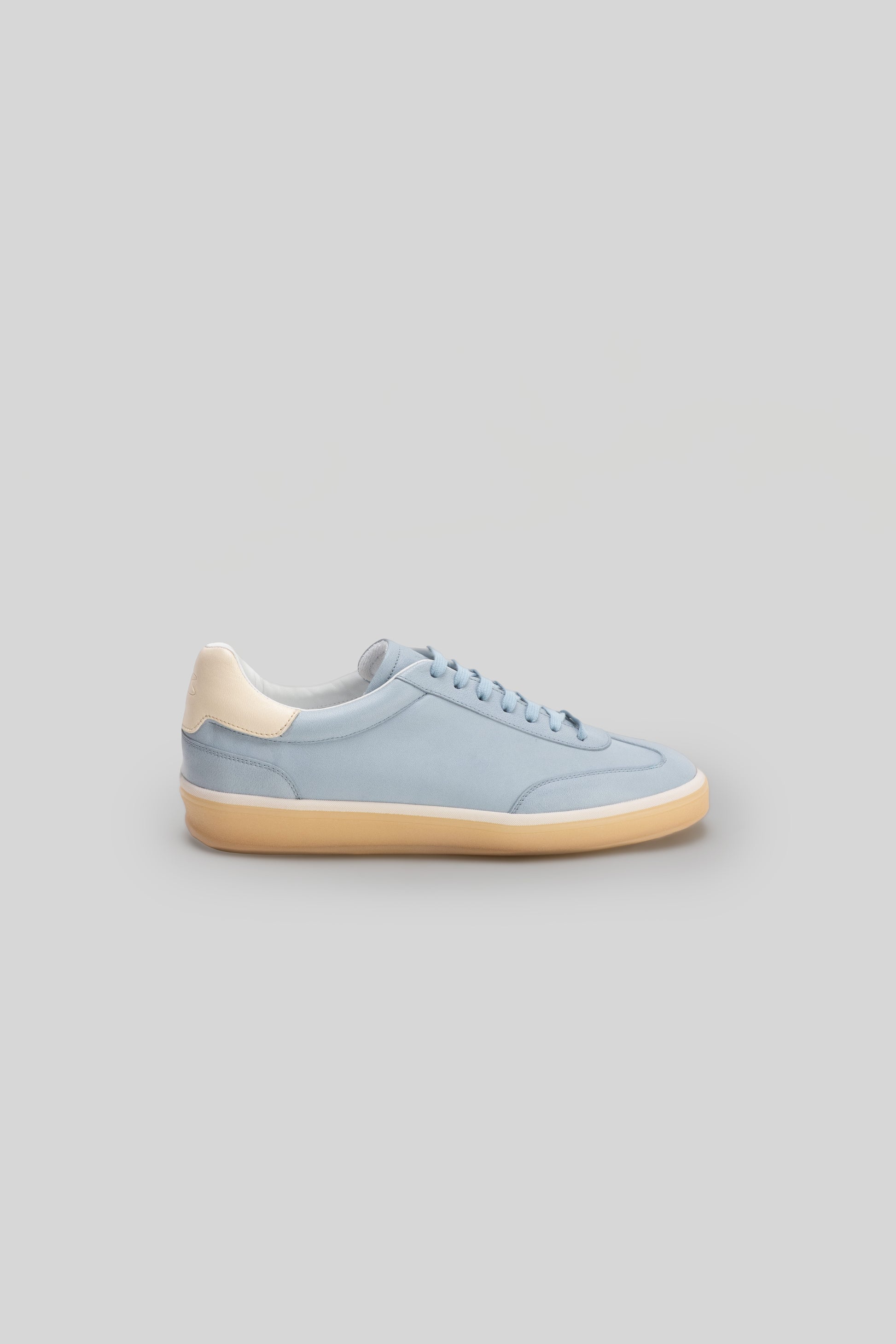 Light blue sneaker with cream-colored heel tab and tan sole, shown in side profile view.