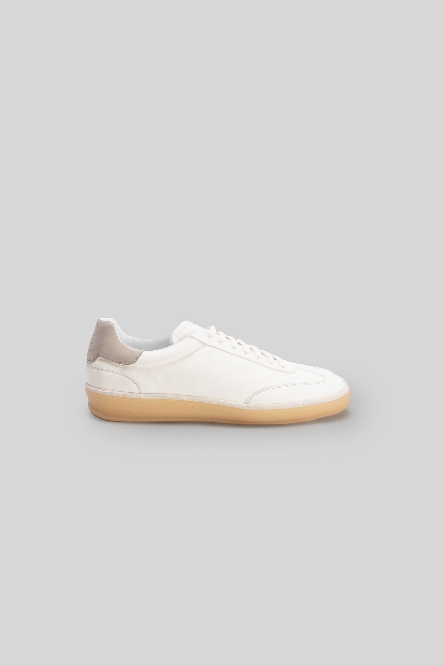 White leather sneaker with tan gum sole and padded heel collar, shown in side profile.