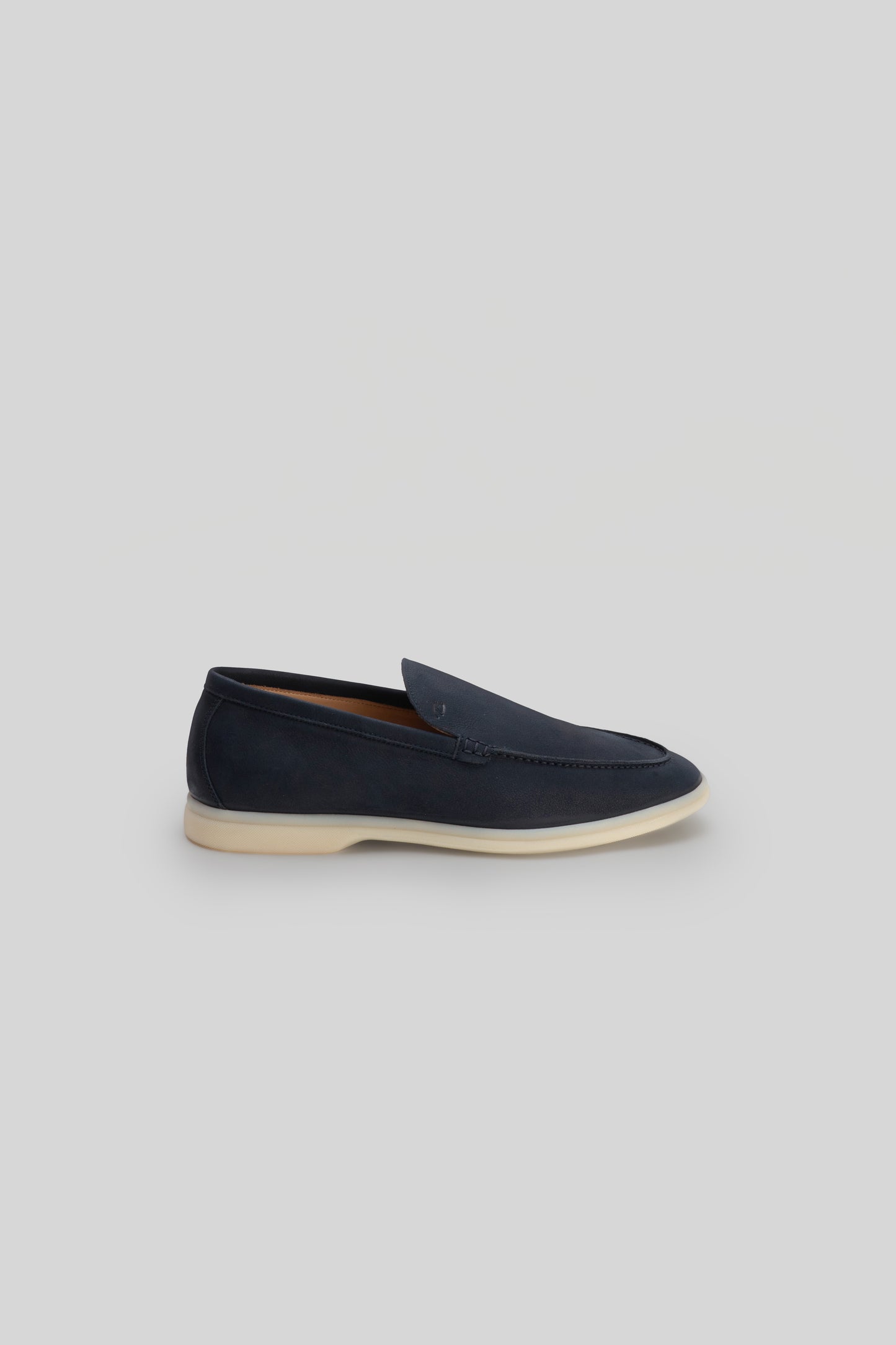 Navy suede loafer with crepe rubber sole and stitched detail on upper.