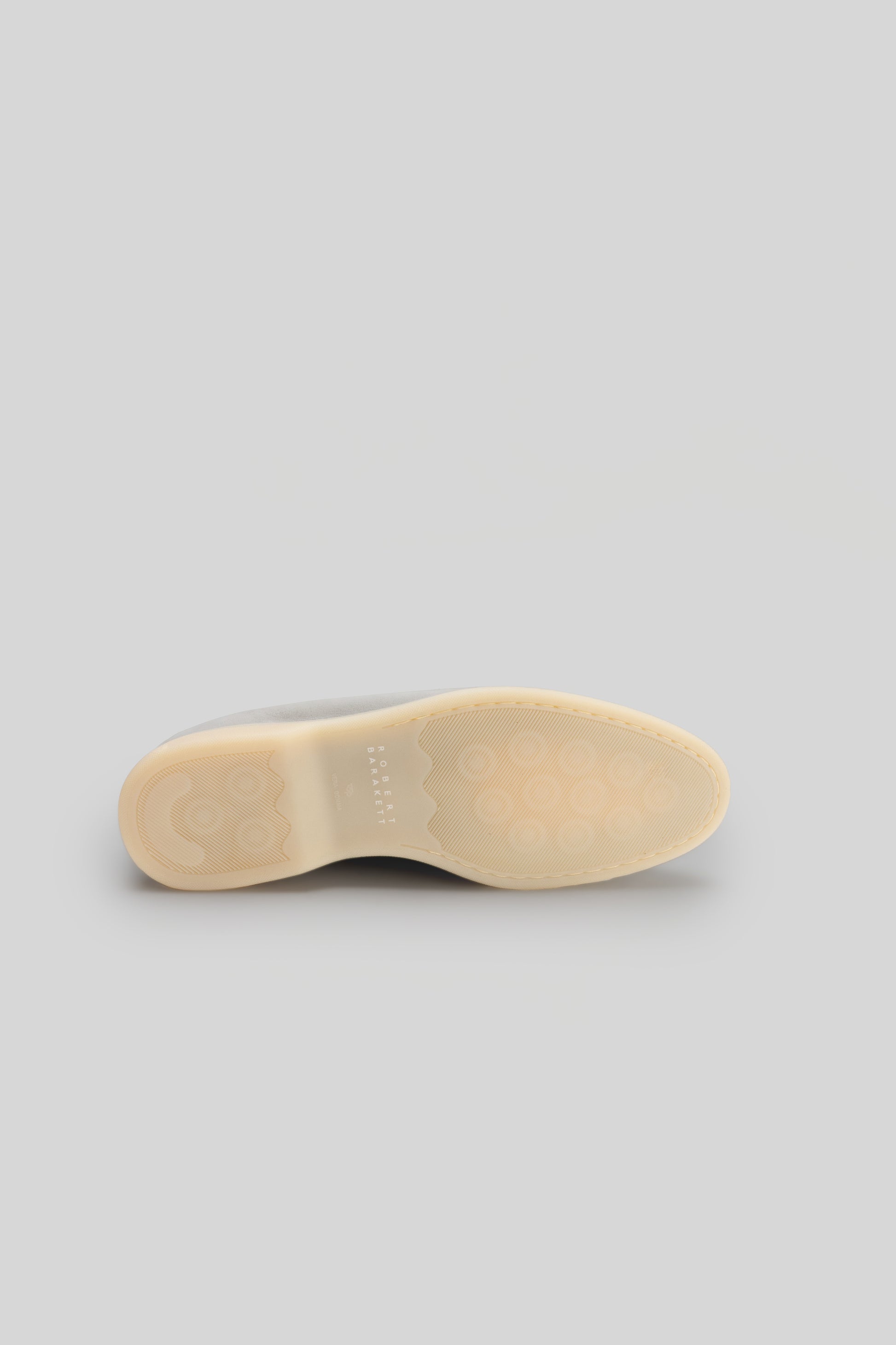 Cream-colored loafer sole with textured grip pattern and minimal branding detail.