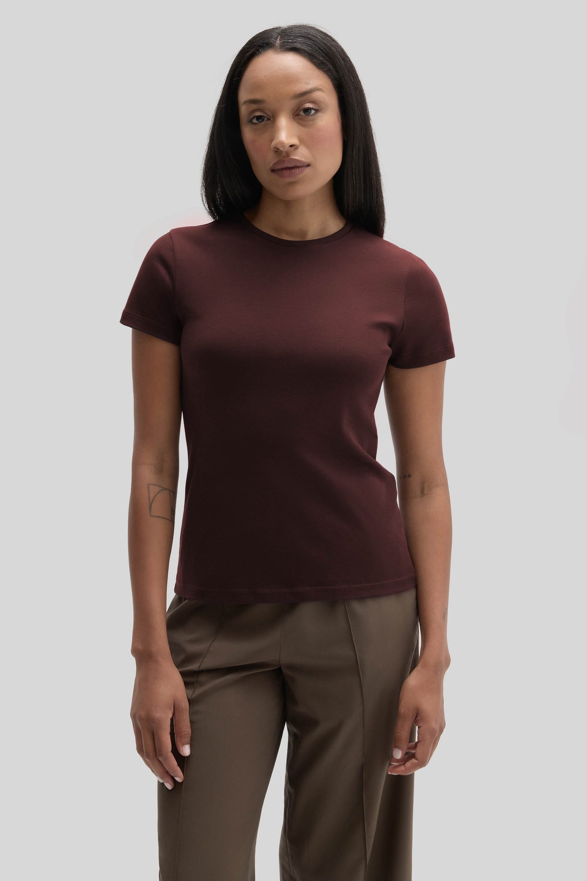 Woman wearing a burgundy crewneck short-sleeve t-shirt with khaki trousers.