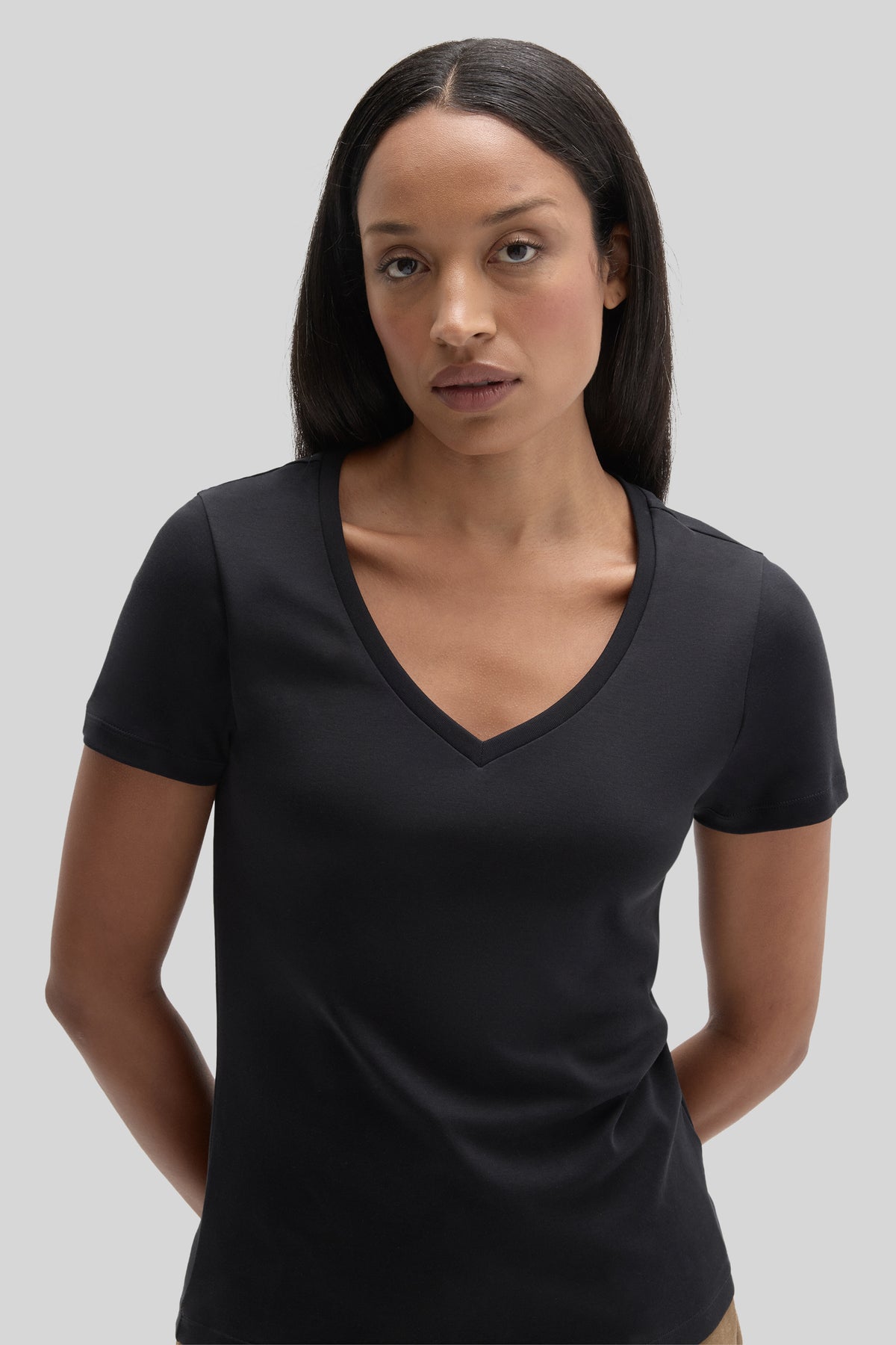 Black women's V-neck t-shirt with short sleeves, shown on a model against a neutral background.